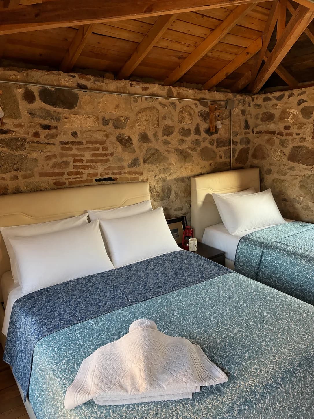 Vesta House Bademli'de taş duvarlı oda ve iki yatak